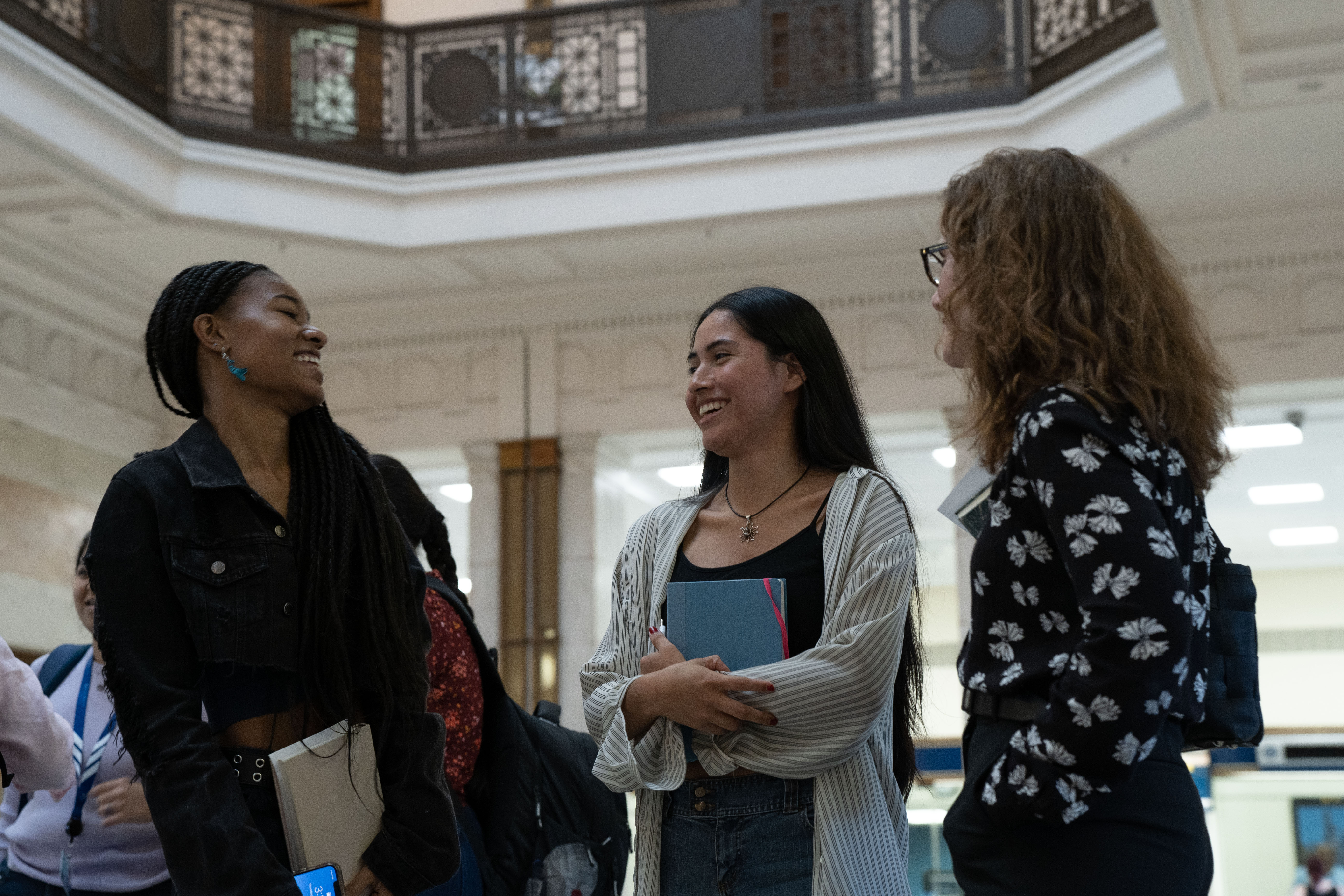 Two students speak with Professor Jane Delury while on assignment in Penn Station.