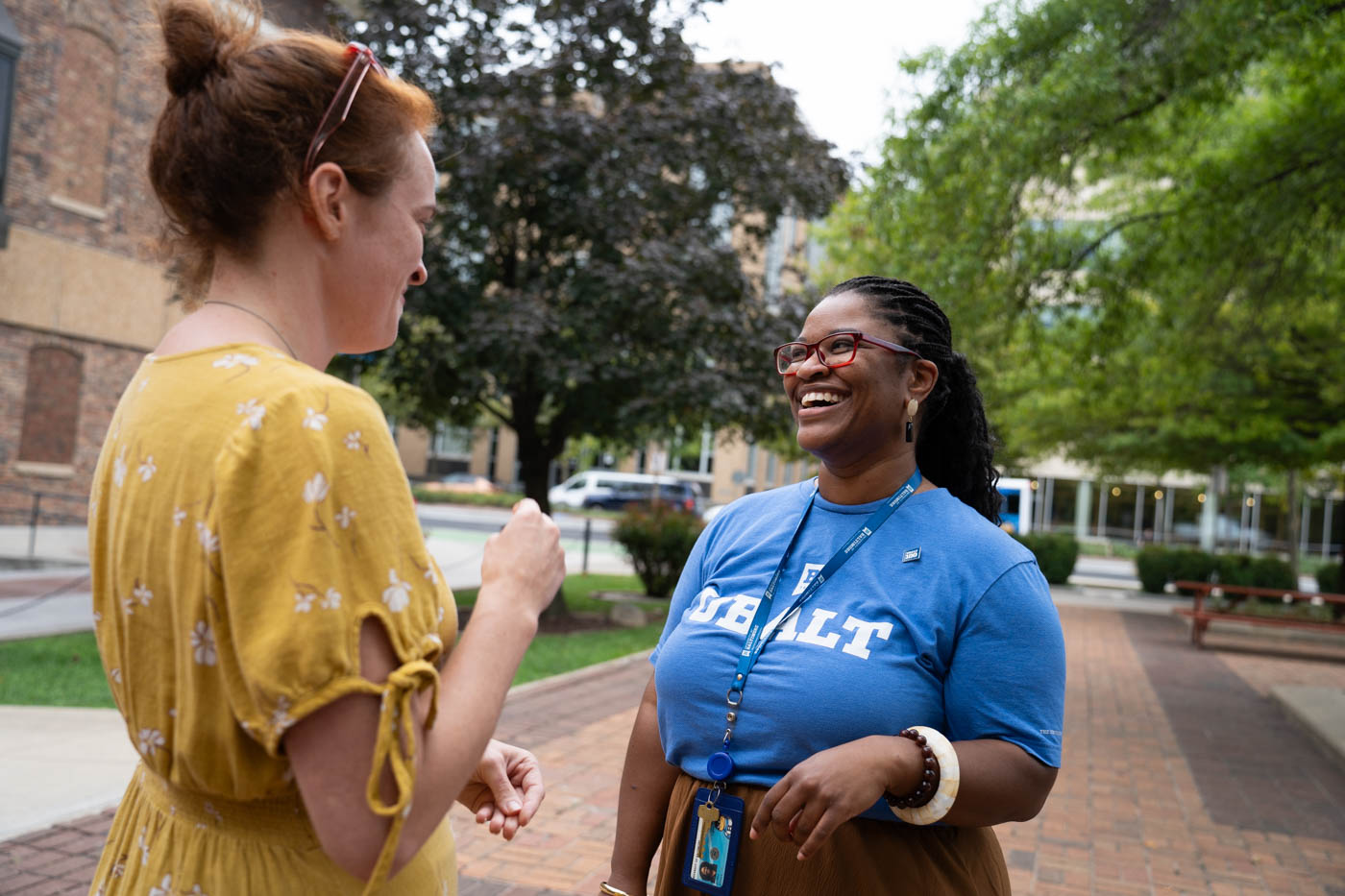 Two women hold a conversation outside.